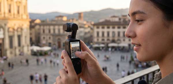 Vlogger using DJI Osmo Pocket 4 zoom function on the OLED touchscreen